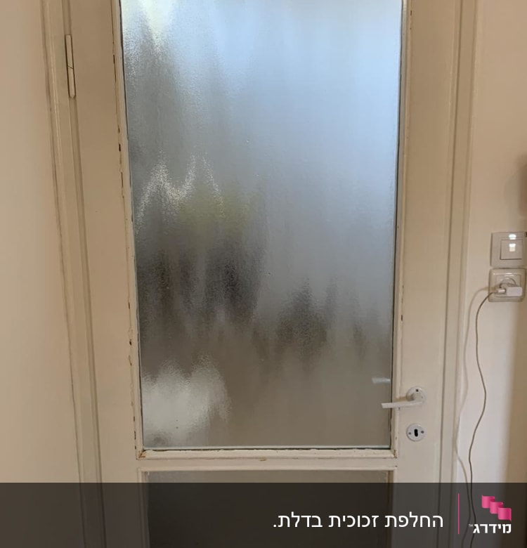 דלת עם זכוכית חלבית במרכז ובחלק התחתון
